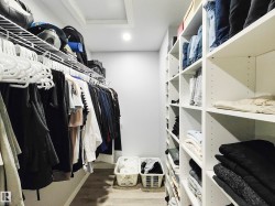Recessed lighting, wood-finish flooring, built-in shelving, wire shelving, and white walls - 