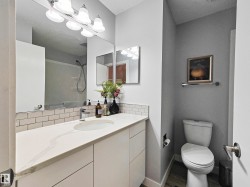 White vanity with a single basin sink and a stone-finish countertop - 