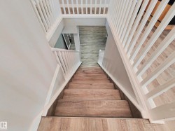 Staircase featuring wood-finish treads and risers with white balusters - 
