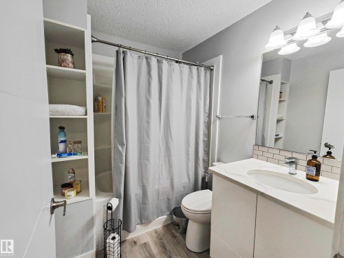 White vanity with a single basin, chrome faucet, and subway tile backsplash - 215 Peter Close Nw, Edmonton, AB 