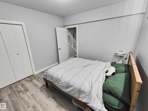 Neutral paint palette, wood-finish flooring, and white bifold closet doors - 215 Peter Close Nw, Edmonton, AB 