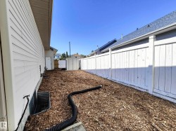 Siding exterior, window well, privacy fencing, and an exterior storage shed - 