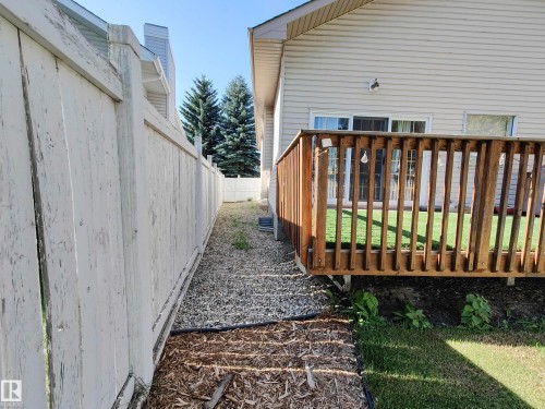 Exterior wood deck with railings, sliding glass door access, and a gravel pathway - 215 Peter Close Nw, Edmonton, AB 