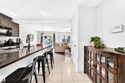 Kitchen featuring dark wood-finish cabinetry, a black range, and a tile backsplash - 