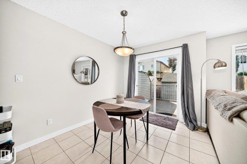 Ceramic tile flooring, sliding glass patio door, and a built-in pendant light fixture - 16832 53 Street Nw, Edmonton, AB 
