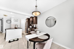 Kitchen featuring dark wood-finish cabinetry, stainless steel appliances, and a tiled backsplash - 
