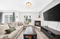 Living space featuring a corner fireplace with a tile surround, large sliding glass door, and wood-finish flooring - 