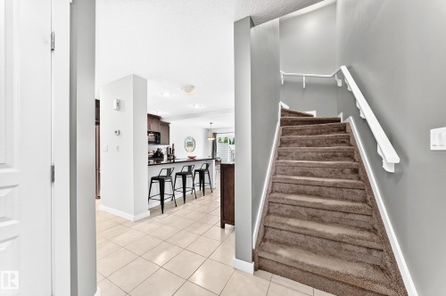 Carpeted staircase with white handrails - 16832 53 Street Nw, Edmonton, AB 