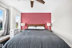 Two large windows with white trim, a wood-finish ceiling fan, and a wood-finish headboard - 