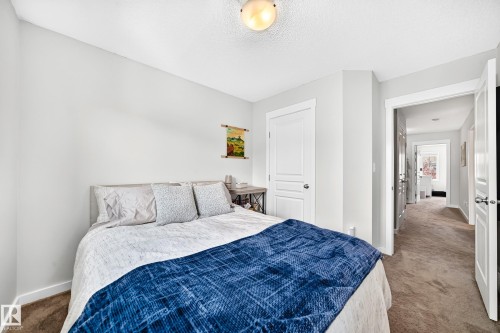 Recessed wall, interior door with white trim, wall-mounted light fixture, and carpeted flooring - 16832 53 Street Nw, Edmonton, AB 