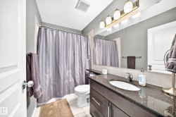 Vanity with a dark stone countertop, undermount sink, and chrome faucet - 
