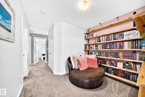 Built-in wood shelving with metal brackets, wall-to-wall carpeting, and a flush-mount ceiling light fixture - 16832 53 Street Nw, Edmonton, AB 