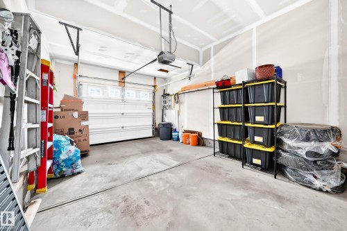 Concrete flooring and a white overhead garage door with upper windows - 16832 53 Street Nw, Edmonton, AB 