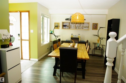 Wood-finish flooring throughout, paired with a large window, a built-in wall shelf, and a staircase with white balusters - 25 Hasen Close, St. Albert, AB 
