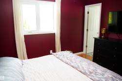 Double-paned window with white trim, wood-finish flooring, and a white six-panel interior door - 
