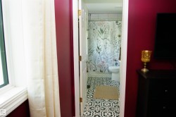 Bathroom featuring patterned floor tiles and a white toilet - 