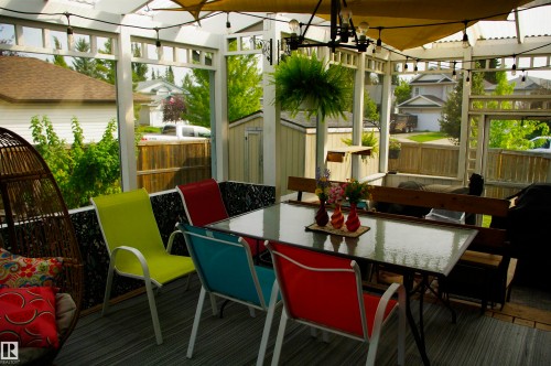 Covered outdoor living area featuring a pergola structure, string lighting, and wood-finish flooring - 25 Hasen Close, St. Albert, AB 