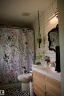 Wood-finish vanity with integrated sink, patterned floor tile, and white subway tile wall - 