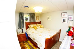 Recessed panel ceiling, overhead light fixture, light gray walls, wood-finish flooring, and a single window - 