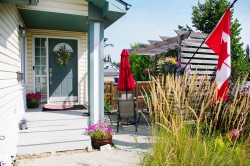 Front entrance with a dark-paneled door and a storm door - 
