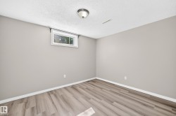Wood-finish flooring, light gray wall paint, white trim, and a window with white casing - 