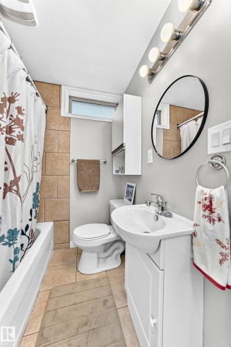 Built-in bathtub with subway tile surround, tile flooring, and a single vanity with storage - 3 Grantham Place, St. Albert, AB 