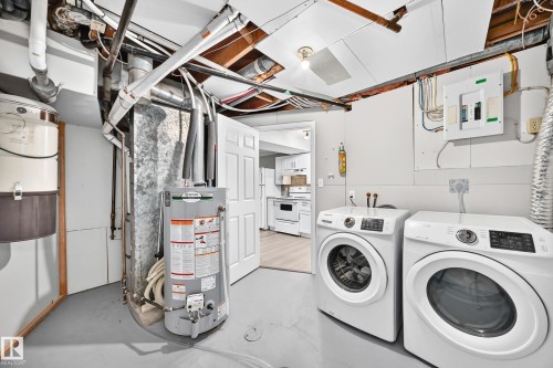Laundry area featuring a side-by-side washer and dryer, water heater, and exposed overhead utilities - 3 Grantham Place, St. Albert, AB 