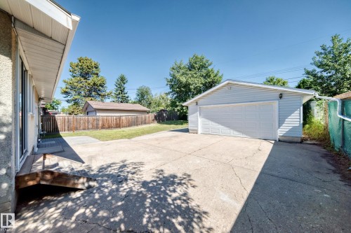 Detached garage with siding exterior, wide concrete driveway, and a wood privacy fence - 3 Grantham Place, St. Albert, AB 
