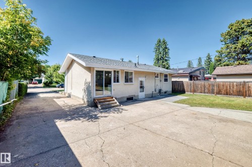 Stucco exterior with a pitched shingle roof, sliding glass patio door, and a private wooden fence - 3 Grantham Place, St. Albert, AB 