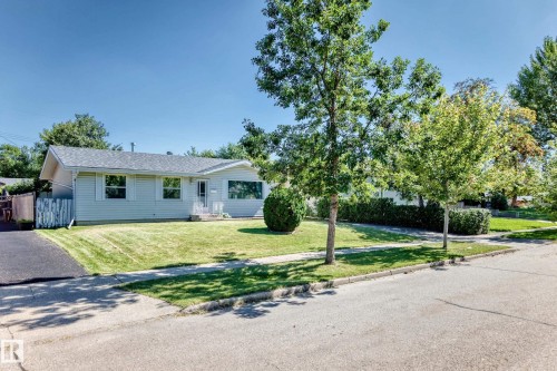 Ranch-style residence featuring light-toned siding, a shingled roof, and an expansive front lawn - 3 Grantham Place, St. Albert, AB 