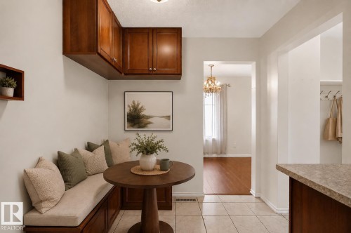 Built-in bench seating with storage, overhead wood cabinetry, tiled flooring, wood-finish flooring in an adjoining room, and a built-in coat rack - 16016 78A Avenue Nw, Edmonton, AB 