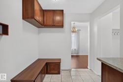 Built-in cabinetry with wood-finish doors, integrated bench seating, and ceramic tile flooring - 