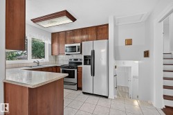 Kitchen featuring wood-finish cabinetry, stainless steel appliances, and a tiled backsplash - 