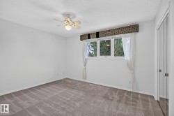 Neutral carpeted flooring, white walls, ceiling fan with integrated lighting, window with a patterned valance, and bi-fold closet doors - 