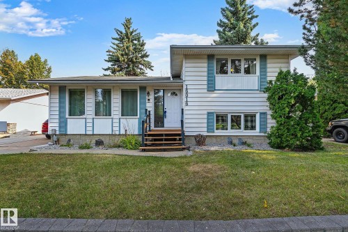 White siding exterior with blue decorative shutters, a wooden entry staircase, and a manicured front lawn - 16016 78A Avenue Nw, Edmonton, AB 