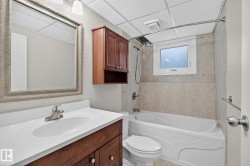 Vanity with integrated sink, wood-finish cabinetry, and brushed nickel faucet - 