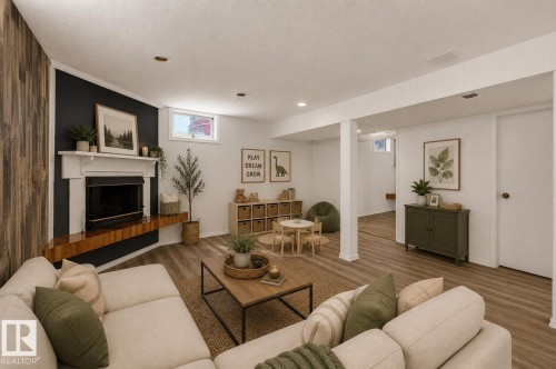 Recessed lighting, wood-finish flooring, white trim, and a fireplace with a white mantel and wood-finish hearth - 16016 78A Avenue Nw, Edmonton, AB 