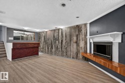 Wood-finish flooring, accent wall with varied wood paneling, built-in bar, wood mantel with integrated shelving, and white fireplace surround - 