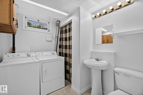 Pedestal sink with chrome faucet, wall-mounted mirror, overhead vanity lighting, and built-in shelving - 16016 78A Avenue Nw, Edmonton, AB 