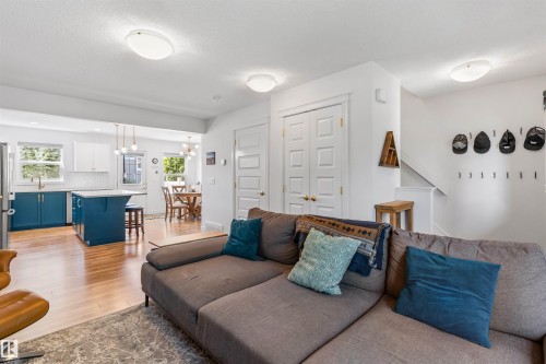 Open-concept living area with wood-finish flooring, recessed lighting, and a white color palette - #71 330 Bulyea Rd Nw, Edmonton, AB 