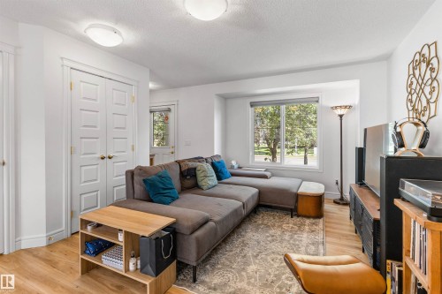 Recessed window with exterior views, wood-finish flooring, white paneled doors, and ceiling-mounted flush lighting - #71 330 Bulyea Rd Nw, Edmonton, AB 