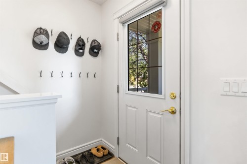 White paneled door with a multi-pane glass insert and brass hardware - #71 330 Bulyea Rd Nw, Edmonton, AB 