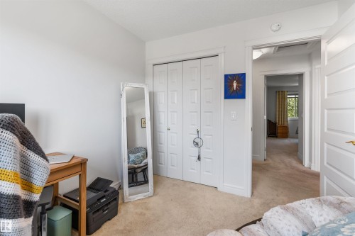 Plush carpeted flooring, white interior doors, and a double-door closet with paneled detailing - #71 330 Bulyea Rd Nw, Edmonton, AB 
