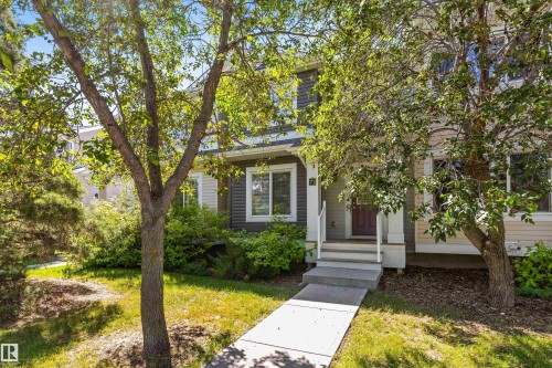 Siding exterior with contrasting trim, concrete walkway, and established landscaping - #71 330 Bulyea Rd Nw, Edmonton, AB 