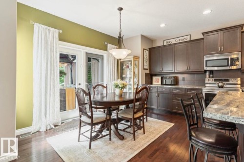 Wood-finish flooring with recessed lighting, dark wood-finish cabinetry, stainless steel appliances, and granite countertops - 22 Voleta Crest, Spruce Grove, AB 