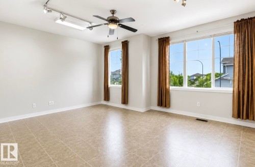 Spacious room featuring tile flooring, a multi-pane window, a ceiling fan, and track lighting - 22 Voleta Crest, Spruce Grove, AB 