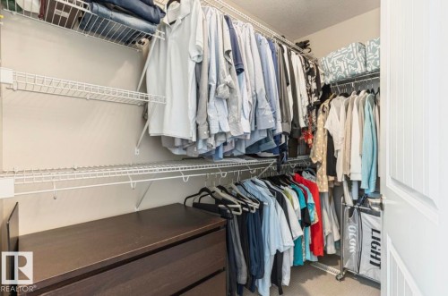 Walk-in closet featuring wire shelving, hanging rods, and a built-in wood-finish dresser - 22 Voleta Crest, Spruce Grove, AB 