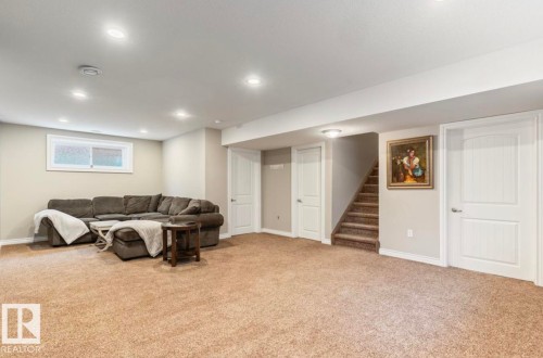 Recessed lighting illuminates this carpeted space featuring a window and white paneled doors - 22 Voleta Crest, Spruce Grove, AB 