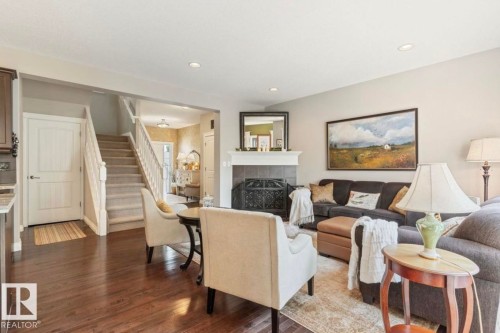 Hardwood flooring, fireplace with mantel, recessed lighting, white trim, and a carpeted staircase - 22 Voleta Crest, Spruce Grove, AB 
