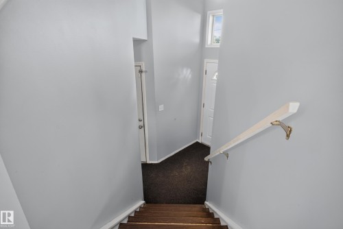 Wood-finish stairs with a light-toned handrail - 13803 130A Avenue Nw, Edmonton, AB 